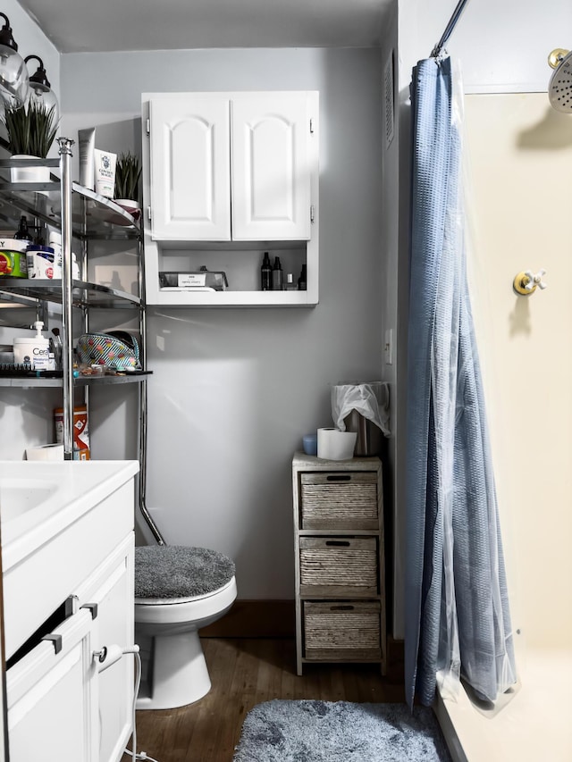 bathroom with a shower with curtain, vanity, hardwood / wood-style flooring, and toilet