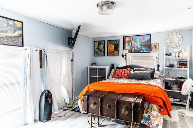 bedroom featuring light wood-type flooring and ornamental molding