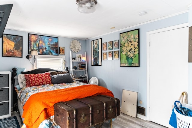 bedroom featuring wood-type flooring and ornamental molding