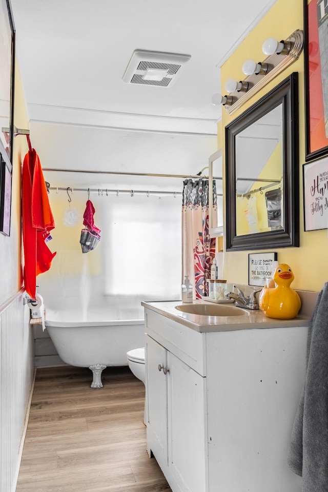 bathroom featuring vanity, toilet, wood-type flooring, and a washtub