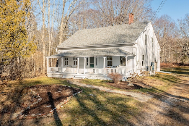 681 Sedgwick Ridge Rd, Sedgwick, ME 04676 - country-style home featuring covered porch, a chimney, a shingled roof, and a front lawn