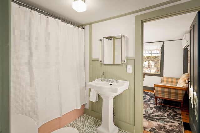 681 Sedgwick Ridge Rd, Sedgwick, ME 04676 - full bath with a wall unit AC, wainscoting, shower / bathtub combination with curtain, and wood finished floors