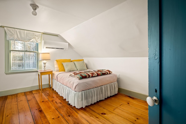 681 Sedgwick Ridge Rd, Sedgwick, ME 04676 - bedroom with a wall unit AC, lofted ceiling, and hardwood / wood-style floors