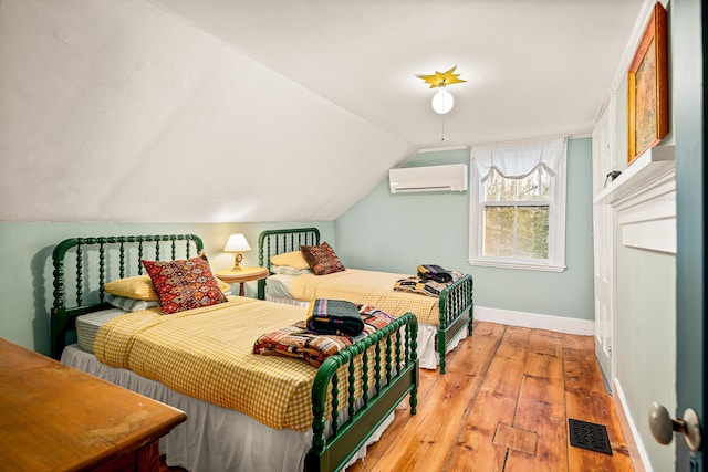 681 Sedgwick Ridge Rd, Sedgwick, ME 04676 - bedroom with an AC wall unit, light wood-style floors, and lofted ceiling