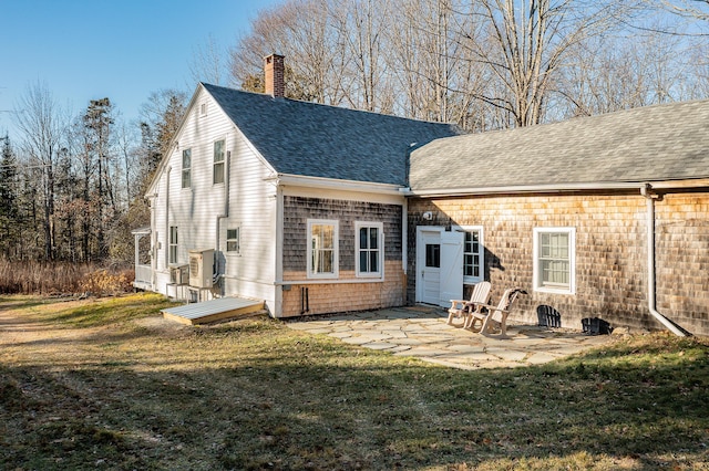 681 Sedgwick Ridge Rd, Sedgwick, ME 04676 - rear view of house with a chimney, a shingled roof, a patio area, and a yard