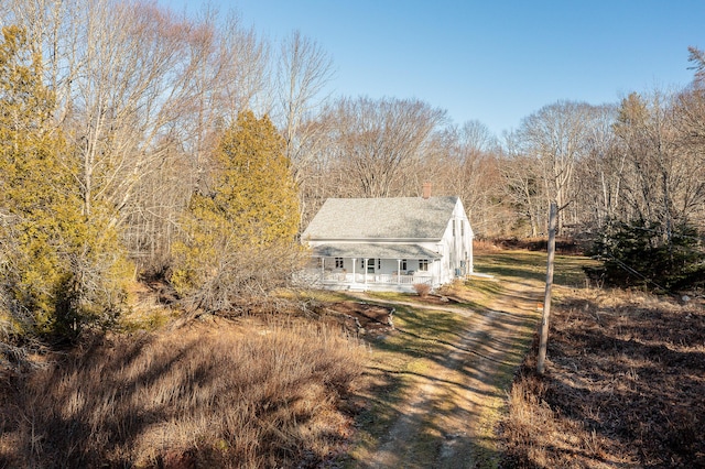 681 Sedgwick Ridge Rd, Sedgwick, ME 04676 - view of front of house with a chimney, a porch, and a shingled roof