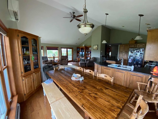 dining room with ceiling fan, sink, high vaulted ceiling, an AC wall unit, and light wood-type flooring