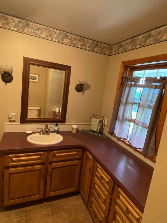 bathroom featuring tile patterned flooring, vanity, and toilet