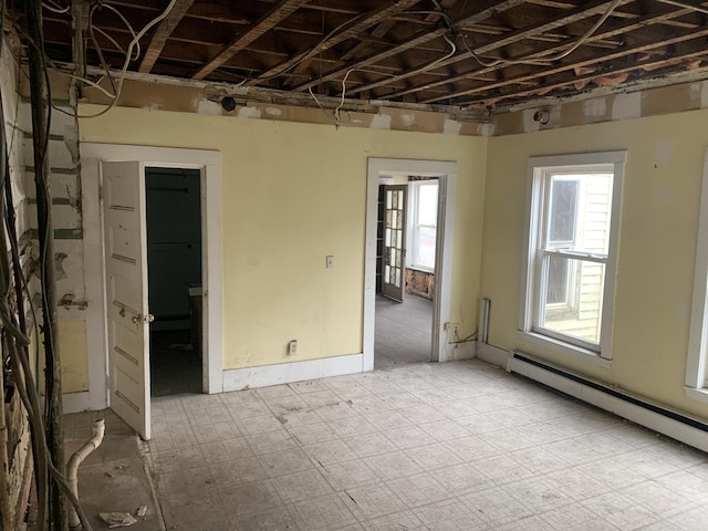 unfurnished room featuring a baseboard heating unit