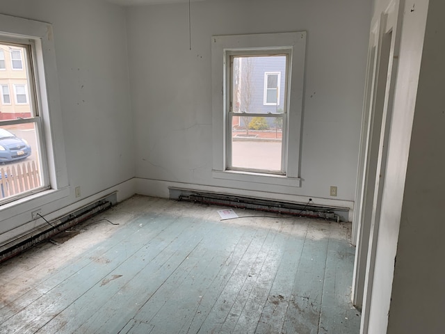 empty room with hardwood / wood-style floors and a healthy amount of sunlight