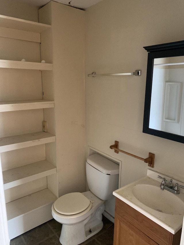 bathroom with toilet, vanity, and tile patterned floors