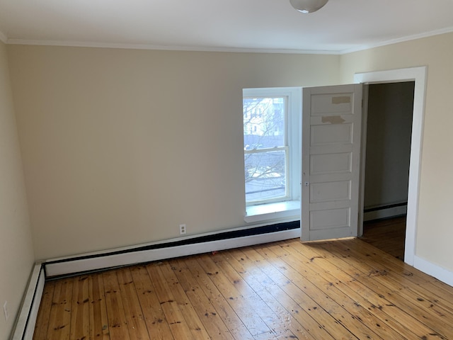 spare room featuring hardwood / wood-style flooring, ornamental molding, and a baseboard heating unit