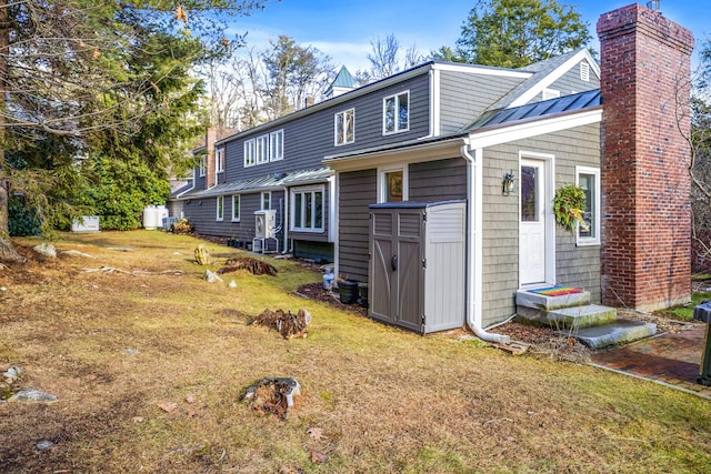 15 Brentwood Dr Unit 4, Cumberland, ME 04110 - rear view of property featuring a yard, a chimney, a standing seam roof, metal roof, and entry steps