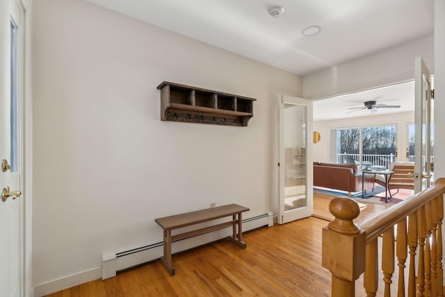 interior space with ceiling fan, baseboard heating, and light hardwood / wood-style floors