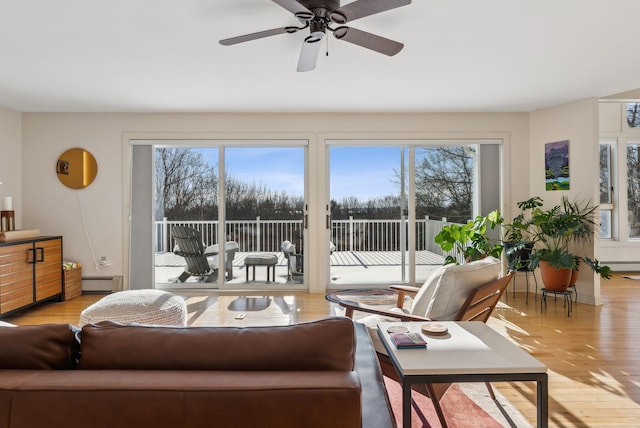 living room featuring a baseboard radiator, plenty of natural light, ceiling fan, and light hardwood / wood-style flooring