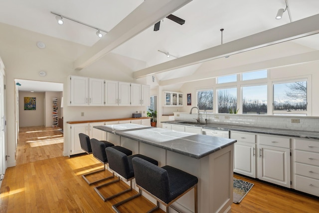 kitchen featuring white cabinetry, a center island, sink, and a kitchen breakfast bar