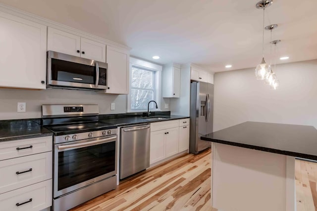 kitchen featuring sink, white cabinets, light wood-type flooring, and appliances with stainless steel finishes