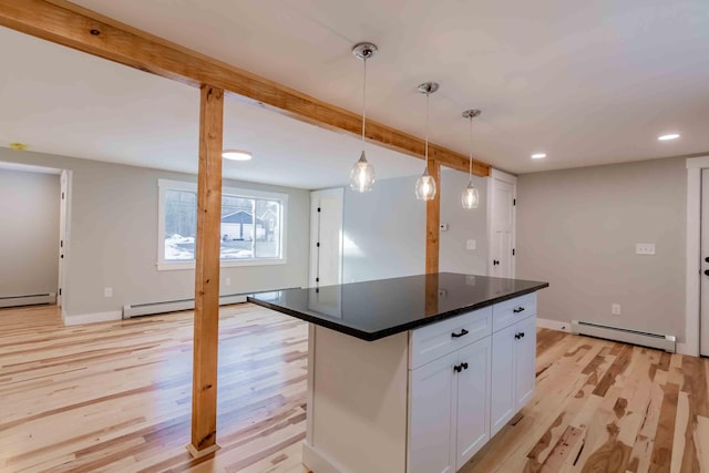 kitchen with light wood-type flooring, a baseboard radiator, and white cabinetry