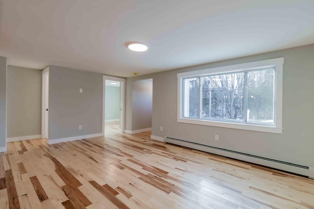 empty room featuring light hardwood / wood-style flooring and a baseboard heating unit