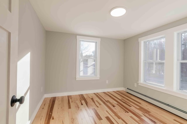 spare room with wood-type flooring and a baseboard radiator