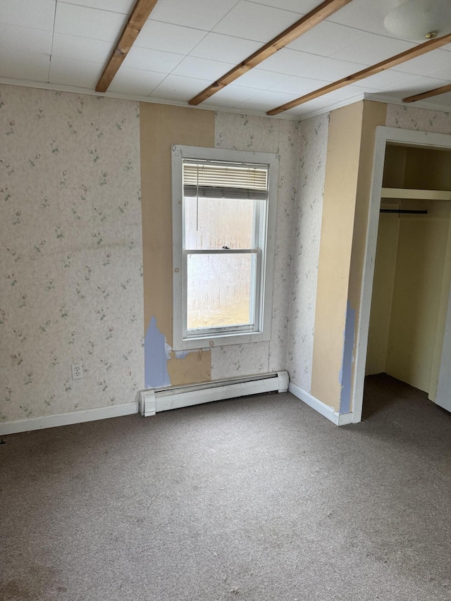 unfurnished bedroom with beam ceiling, carpet floors, and a baseboard radiator