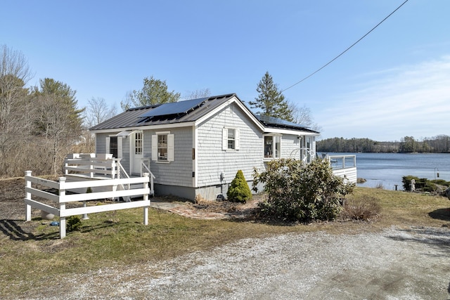 283 Mills Rd, Newcastle, ME 04553 - view of side of home with metal roof, a deck with water view, and roof mounted solar panels