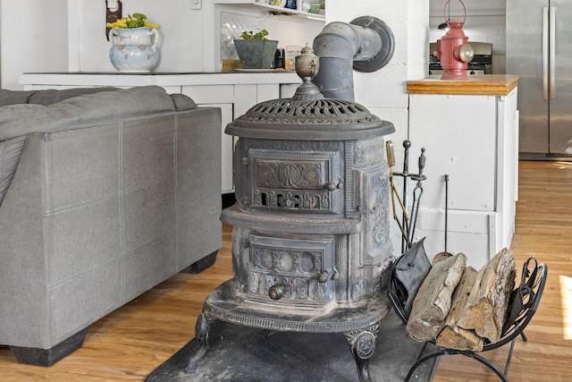 283 Mills Rd, Newcastle, ME 04553 - details featuring wood finished floors, a wood stove, and stainless steel fridge