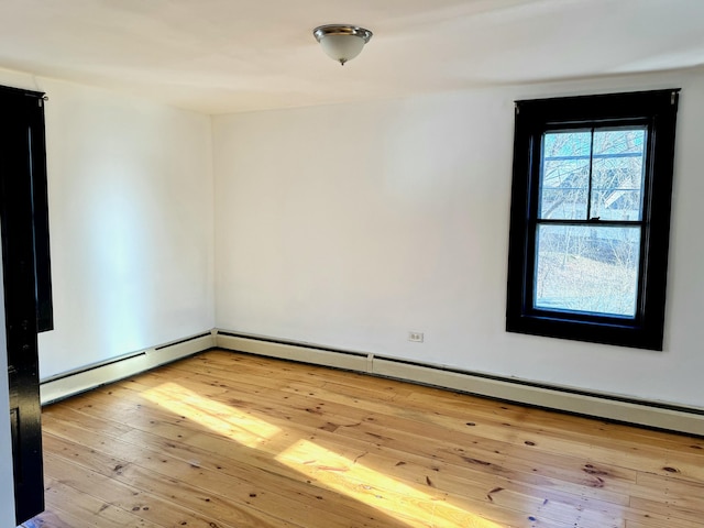 empty room featuring light hardwood / wood-style floors and baseboard heating