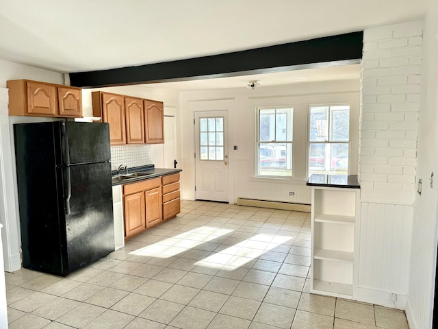 kitchen with black fridge, plenty of natural light, beamed ceiling, and a baseboard radiator