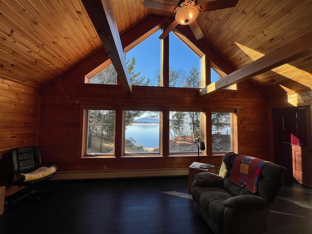 living room with a wealth of natural light, beamed ceiling, dark wood-type flooring, and ceiling fan