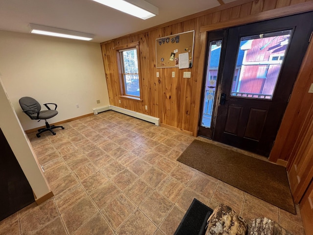 entrance foyer with a baseboard heating unit and wooden walls