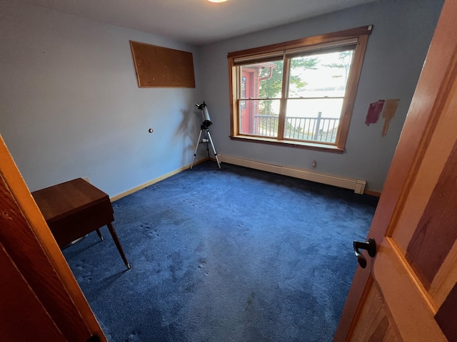 spare room with dark carpet and a baseboard radiator