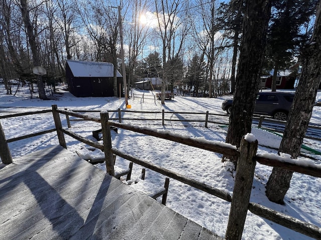 yard layered in snow with an outdoor structure