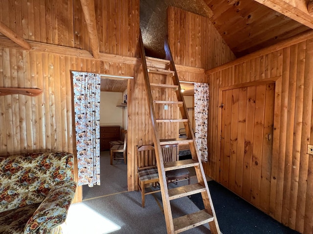 bedroom with wood walls, carpet, and vaulted ceiling