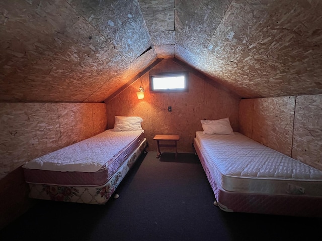 bedroom with vaulted ceiling and dark colored carpet