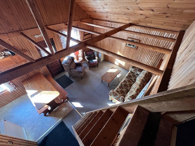 unfurnished living room featuring wood walls and high vaulted ceiling