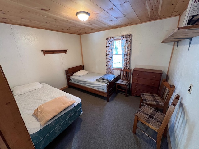 bedroom with wood ceiling and dark carpet