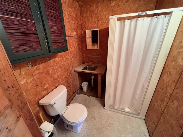 bathroom featuring walk in shower, sink, and toilet