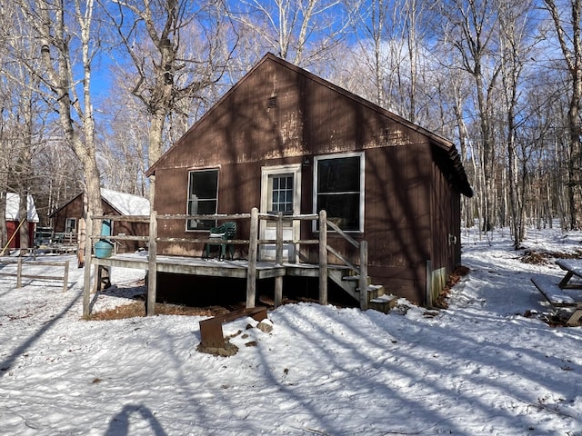 snow covered rear of property with a wooden deck