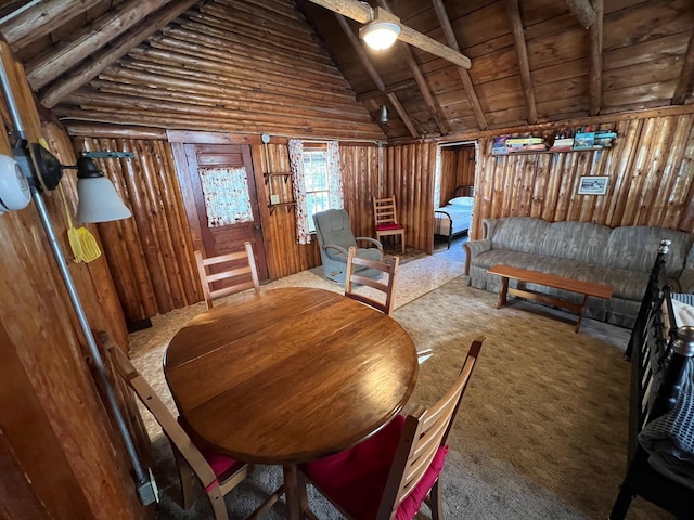 sitting room with carpet flooring, vaulted ceiling with beams, and wooden walls