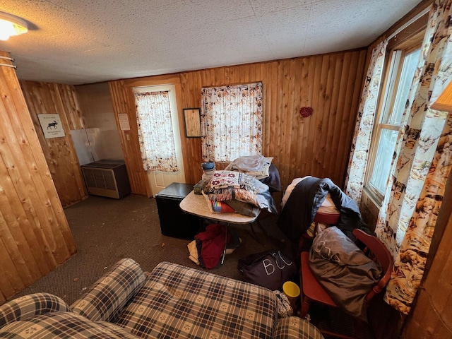 bedroom featuring carpet flooring, wood walls, and a textured ceiling