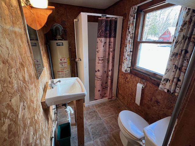 bathroom featuring a shower with curtain, toilet, gas water heater, and sink