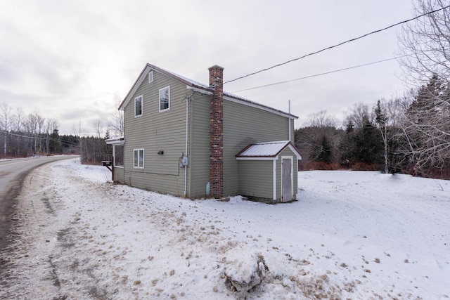 view of snow covered exterior with a storage unit