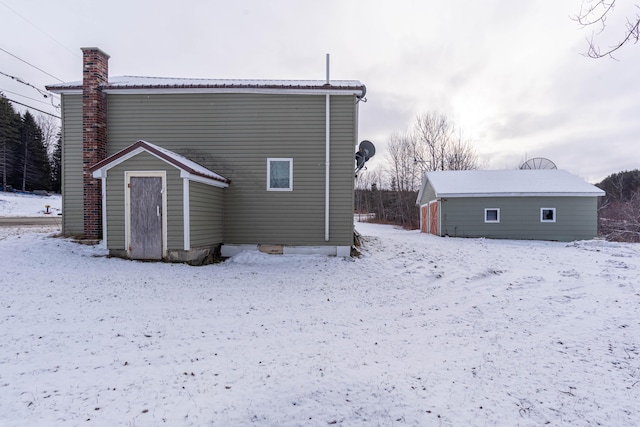 view of snow covered back of property