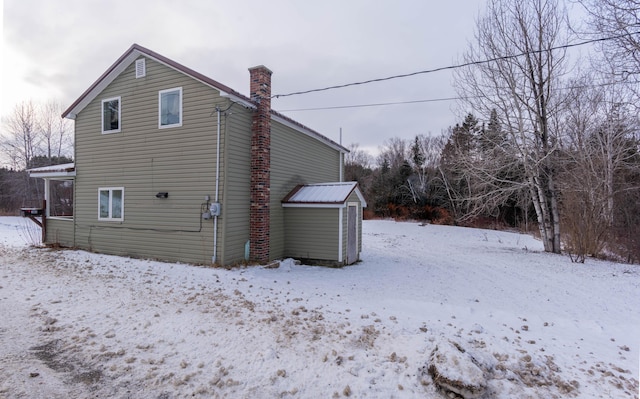 snow covered property with an outdoor structure