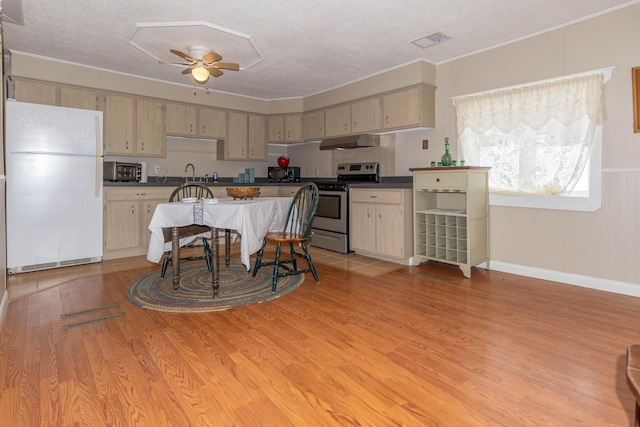 kitchen featuring light brown cabinets, white fridge, stainless steel electric stove, and ceiling fan