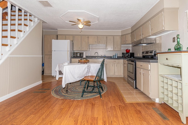 kitchen with electric stove, sink, ceiling fan, a textured ceiling, and white fridge