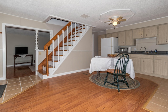 kitchen with white fridge, sink, a textured ceiling, and light brown cabinets