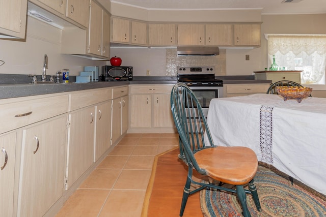 kitchen featuring light brown cabinets, wall chimney range hood, crown molding, and light tile patterned floors