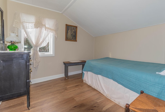 bedroom featuring wood-type flooring and vaulted ceiling